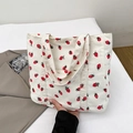 Cream corduroy tote bag featuring red strawberry patterns and sturdy double handles - White