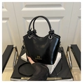 Détail du sac à main noir brillant avec logo doré et poignée décorative nouée chic - Noir
