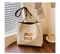 Detail van zomerse strooien draagtas met geweven textuur, leren ketting en borduursel - Beige En Bruin