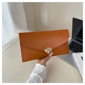 Caramel envelope clutch bag with artistic gold metal buckle shown in a modern lifestyle setting - Brown