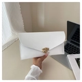 Close-up of white envelope clutch bag with gold geometric buckle on an office desk - White
