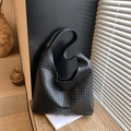 Bolso tote de cuero trenzado negro con correa ancha en una escena minimalista - Negro