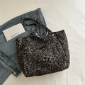 Chic grey leopard print tote bag with front pocket shown against a denim jacket - Leopard Print (Coffee)