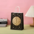 Detail of black paper gift bag with golden glitter clock and star patterns and white handles - Vintage Clock And Stars Style (242-4)