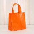 Close-up of orange non-woven tote bag showing diamond woven texture and sturdy handle - Orange