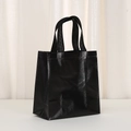 Close-up of black glossy non-woven tote bag with grid texture and waterproof film coating - Black