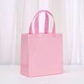 Close-up of pink non-woven gift bag with textured finish and reinforced handle - 23*22*11 / Macaron Pink