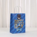 Close-up of blue Father's Day paper gift bag with gold typography and white cord handles - Blue Diagonal Stripes Hat and Bow Tie (471-1) / 21x15x8cm
