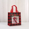 Detalle de bolsa de regalo de Navidad a cuadros rojos y negros con estampados navideños - 23x22x11cm