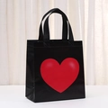 Detailed texture of black non-woven gift bag with a vibrant red heart print - 23x22x11 / Black