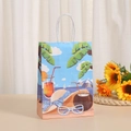 Detalle de bolsa de regalo de papel kraft con motivos tropicales y asas de cuerda blancas - Estilo Objetos de Verano (276-1)