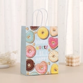 Detail of blue paper donut gift bag with white handles and donut worry be happy text - Light Blue Slogan Style (424-4)