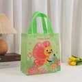 Dettaglio di un sacchetto regalo verde per Pasqua in TNT con farfalla e uovo stampati - Farfalla Verde