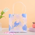 Detail der halbtransparenten Geschenktüte mit tropischem Druck und weichen Griffen - 21.5x10x22 / Blau