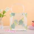 Halbtransparente PP-Geschenktüte mit Tropenblatt-Druck und runden Griffen - 21.5x10x22 / Grün