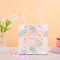 Halbtransparente Geschenktasche aus Kunststoff mit tropischen Blättern und Griffen - 21.5x10x22 / Rosa