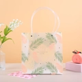 Matte, halbtransparente Geschenktüte mit tropischen Blättern und stabilen Rohrgriffen - 21.5x10x22 / Orange