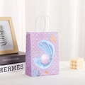 Bolsa de regalo de papel kraft lila con estampados marinos y asas de cuerda para fiestas - Criaturas Marinas Púrpuras (384-5)