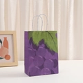 Dettaglio di un sacchetto regalo in carta kraft con stampa d'uva e manici a corda - Motivo Uva (260-6)