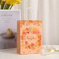 Detail of Thanksgiving kraft paper gift bag with pumpkin prints and white rope handles - A Little Pumpkin Is On The Way (Wreath Style) / 21x15x8