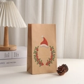 Detail der Weihnachts-Papiertüte aus Kraftpapier mit Kranz und Merry Xmas Aufdruck - Weihnachtsmütze Beerenkranz Muster
