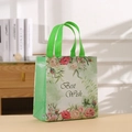 Dettaglio di un sacchetto regalo floreale in TNT con testo Best Wish e manici verdi in casa - 29*27*12 / Verde (4003-1)