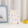 Detail of white Easter paper gift bag with cute rabbit prints and rope handles - Bunny and Egg Basket Style (375-6)