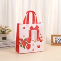 Detailed view of a white non-woven gift bag with red rose design and sturdy red handles - Floral Gift Box with Pearl Pattern (4009-1) / L