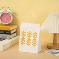 Detail of a white paper gift bag with yellow botanical prints and sturdy twisted handles - White Yellow Leaf (902 White)