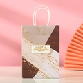 Detalle de bolsa de regalo con patrón de mármol, toques dorados y etiqueta floral - Al21*An15*Pr8 / Mármol Rosa Marrón (236-3)
