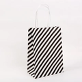 Geschenktüte aus Kraftpapier mit schwarz-weißen Diagonalstreifen und weißen Griffen - L / Schwarz