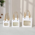 Three white paper gift bags with windows and cartoon smile faces in various sizes - Small / White