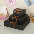 Three sizes of black square gift boxes with brown satin bows in a tiered display - Small / Black