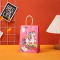 Detailed view of pink unicorn gift bag with rainbow prints on a colorful tabletop - Pink Unicorn (402-1) / 15*11*6