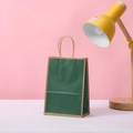Dettaglio del sacchetto regalo in carta kraft verde scuro con manici intrecciati - Stile Verde Scuro / 21x15x8cm