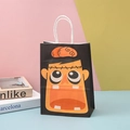 Close-up of a black Halloween gift bag with a vibrant orange cartoon monster face and handles - Black Cartoon Monster Style (15)