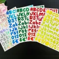 Macro view of colorful laser alphabet stickers for cups and laptop decorations - Flat Laser / Gold