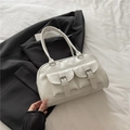 Bolso bowling de cuero blanco minimalista con bolsillos sobre una chaqueta negra - Blanco
