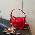 Chic red patent leather handbag with top handle and metal chain strap on books - Red