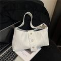 Minimalist white leather underarm bag with gold eyelet details on a modern office desk - White