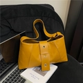 Chic yellow underarm bag with decorative belt buckle and eyelets on a black chair - Brown