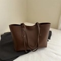 Dark brown matte leather tote bag with FASHION patch on a minimal background - Brown