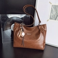 Brown faux leather tote bag with stylish chain and baseball charm on a wooden desk - With Pendant / Brown