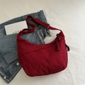 Red corduroy dumpling crossbody bag with adjustable strap on white fabric background - Red