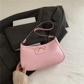 Bolso de hombro en charol rosa con lazo metálico dorado y correa de contraste - Rosa