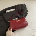 Bolso de hombro en charol rojo brillante con elegante lazo de metal dorado - Rojo