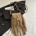 Bruine suède bohemian crossbody tas met franjes en houten kralen op een zwart colbert - Khaki