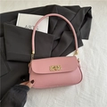 Pink leather shoulder bag with a gold braided metal clasp and a cylindrical top handle - Pink