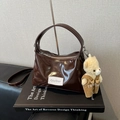 Bolso nube de charol marrón oscuro con colgante de oso y etiqueta Qiyllur - Café Con Colgante