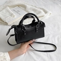 Glossy black mini tote bag with silver hardware and thin shoulder strap in hand - Black
